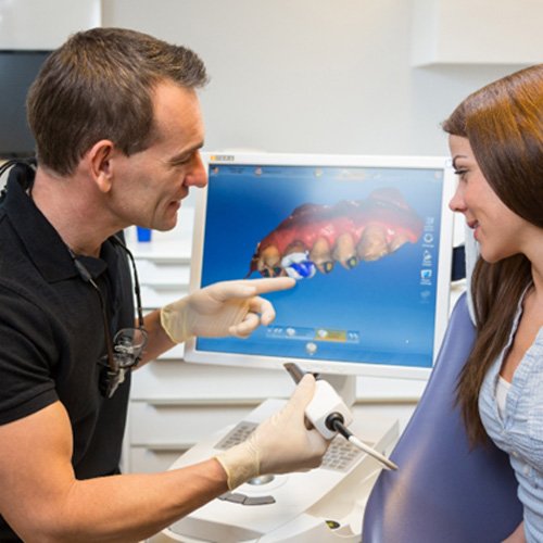 Patient listening to dentist explain CEREC crowns in Camp Hill
