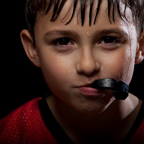 young boy biting mouthguard