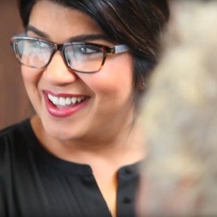 team member with glasses smiling