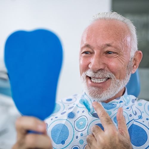 man checking smile in blue mirror