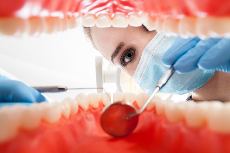 A dentist examining a person’s mouth.