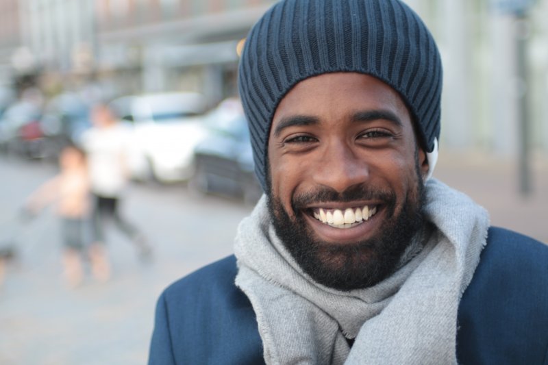 man wearing winter accessories and smiling