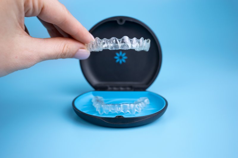 Person holding Invisalign aligners and protective case